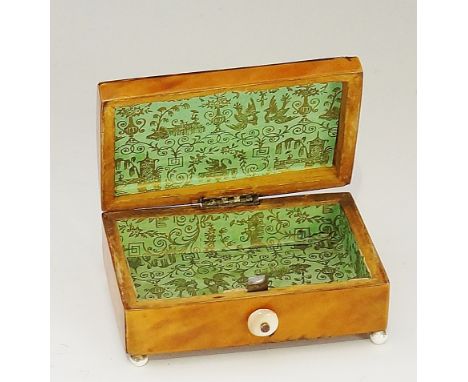 An early 19th Century rectangular tortoiseshell veneered box, the shallow domed hinged lid inlaid to the centre with a white 