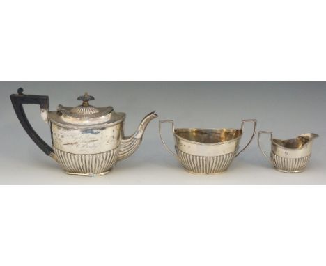 A Victorian three piece silver tea service comprising: teapot, cream jug and sucrier, boat shaped half lobed bodies, the teap