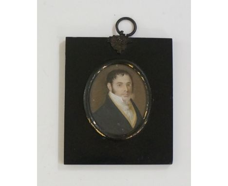 An early 19th Century oval portrait miniature of a gentleman wearing black jacket and cream waistcoat, watercolour, 6.3cm x 5