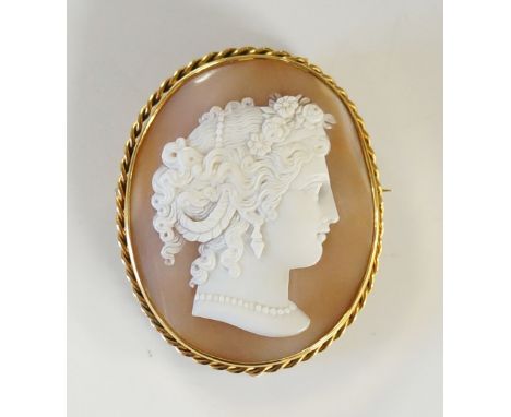 A good Victorian shell cameo, the oval finely carved with a female's head her hair ornately dressed with pearls and flowers, 