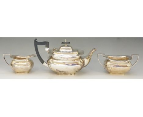 A silver tea set comprising: teapot, cream jug and sucrier, plain boat shaped bodies with oblong feet and angular handles, th