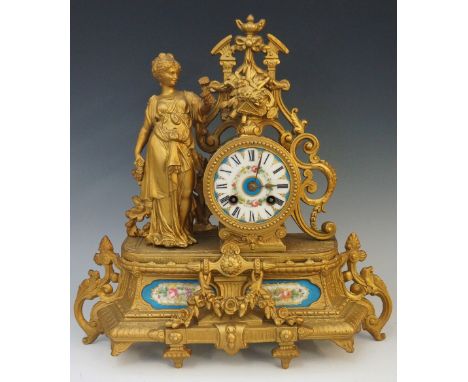 A late Victorian gold painted white metal mantel clock, the cylindrical case painted with floral garland and Roman numerals o