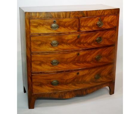 A Regency mahogany caddy top bow-front chest of drawers, the top outlined with ebonised stringing above a figured frieze, two