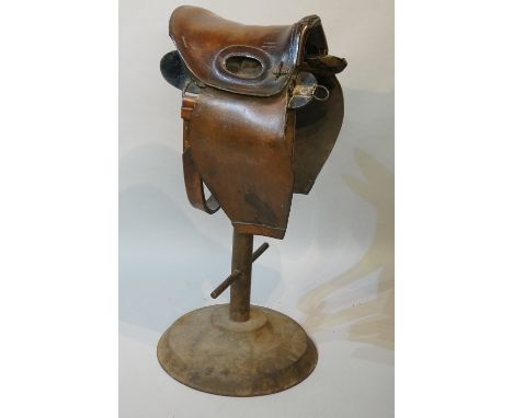 An unusual saddle structure affixed to a metal stand, likely a British Army 'artillery' saddle, the short tree with large ova