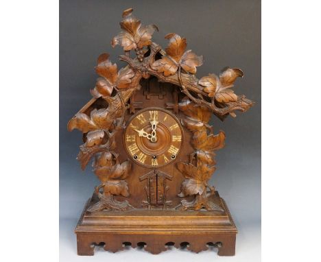 A rare Black Forest 'trumpeter' cuckoo clock of conventional design with applied vine, leaf and branch cresting, the recessed