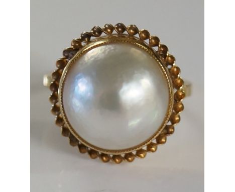 A ladies 9ct gold mounted Mabe pearl ring, the deep collet setting applied rope twist border, ring size O