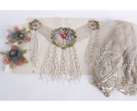 An early 20th century embroidered and beaded fringed dress panel, worked with clusters of colourful beads surrounding a centr