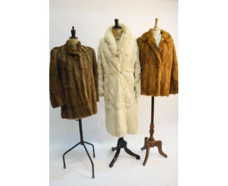 A group of vintage fur items, including: two 1940s fox fur capes, a mink jacket, a musquash coat, a fur-lined raincoat, a bea