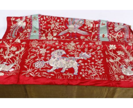 A Chinese red silk wall hanging, showing a central appliqué figure of a woman beside a small deer with a bat just above her h