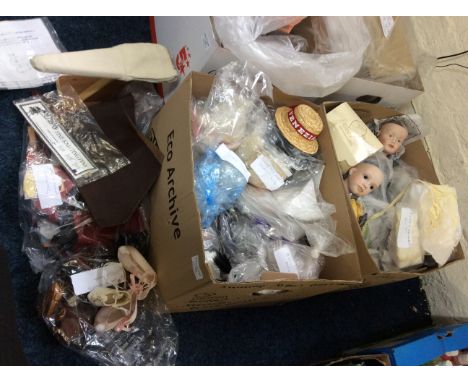 Two boxes of various dolls head with dolls clothes and accesories, a miniboard kit and miniature needlework tools.