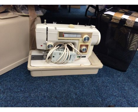 A New Home sewing machine in case with repairs tools and loose thread, together with a Fellowes paper shredder.