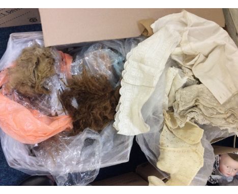 Two boxes of antique dolls clothes, special materials for doll dressing, dolls wigs, wig tools and a teddy bear making kit.