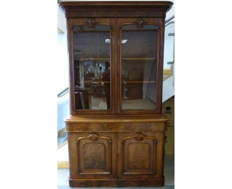 An early Victorian mahogany glazed bookcase, with wide moulded stepped cornice, twin glazed doors with moulded and carved bea