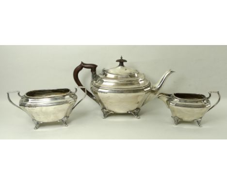 An Edwardian three piece silver tea set, of oblong form with canted corner, comprising teapot with Bakelite handle and finial