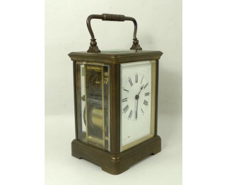 A brass cased repeating carriage clock, the white enamel dial with Roman numerals, bevelled glass, and bevelled oval glass in