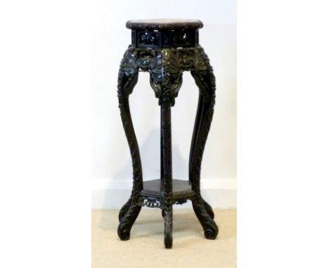 A Chinese hardwood hexagonal urn stand, the six hardwood legs deeply carved and pierced, with bat design, the top inset with 