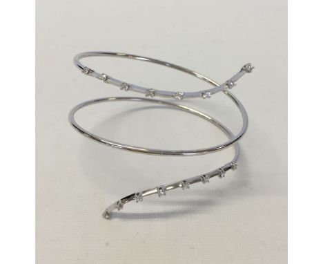 An 18ct white gold & diamond spiral bangle. Set with 16 diamonds each of approx 0.03 carat. Total weight approx 10g.