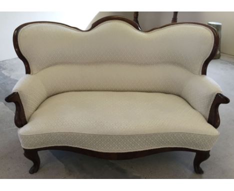 A Victorian mahogany framed sofa in oatmeal damask upholstery.