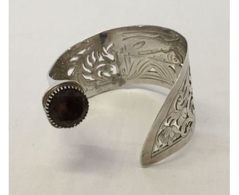 A HM Victorian silver bangle made from a fish serving knife with smokey quartz stone and pierced & engraved fish decoration. 