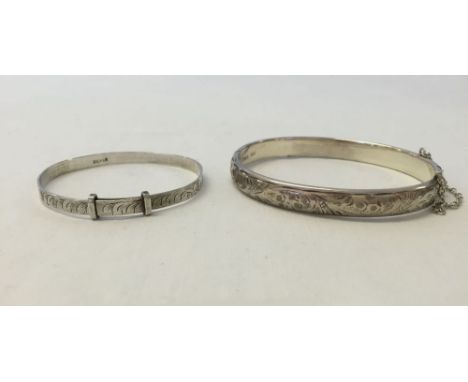 2 silver bangles, one a childs adjustable christening bangle and a hallmarked hinged bangle with engraving.
