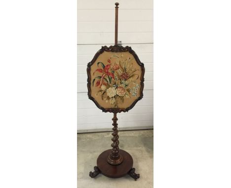 A Victorian mahogany firescreen on spiral pedestal leg with 3 scroll feet and brass casters.