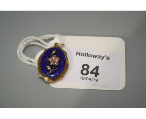 A Victorian ruby, pearl and enamel locket, shaped oval with blue guilloché enamel ground with a single central flower compose