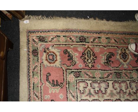 A 20th century Indian wool carpet, woven with a stepped central lozenge medallion within a conforming guard on a cream, pink 