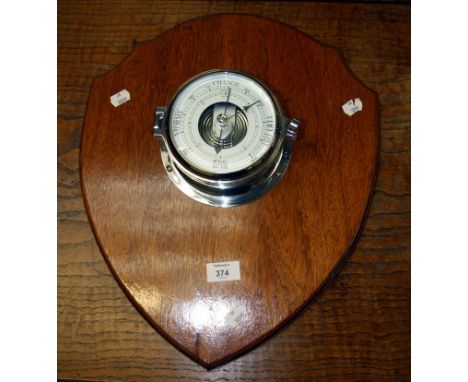 An F C C chrome cased ship's barometer, 18cm diameter, mounted upon an oak shield