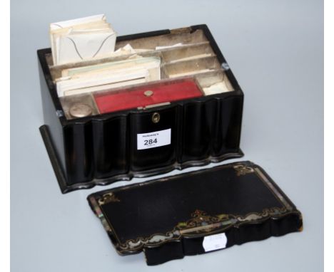 A Victorian papier maché tea caddy, later converted for stationery, containing several dozen largely Edwardian visiting cards