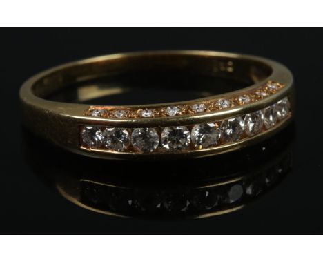 An 18ct gold 9 stone channel set diamond ring with smaller rows set either side.3.3g