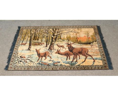 A large wool tapestry depicting deer within a forest landscape and decorated with blue fringed edges. Approx. dimensions 185c