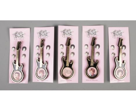 A set of five Queen plastic guitar brooches, four featuring a portrait of a band member, the other the band name. All backed 