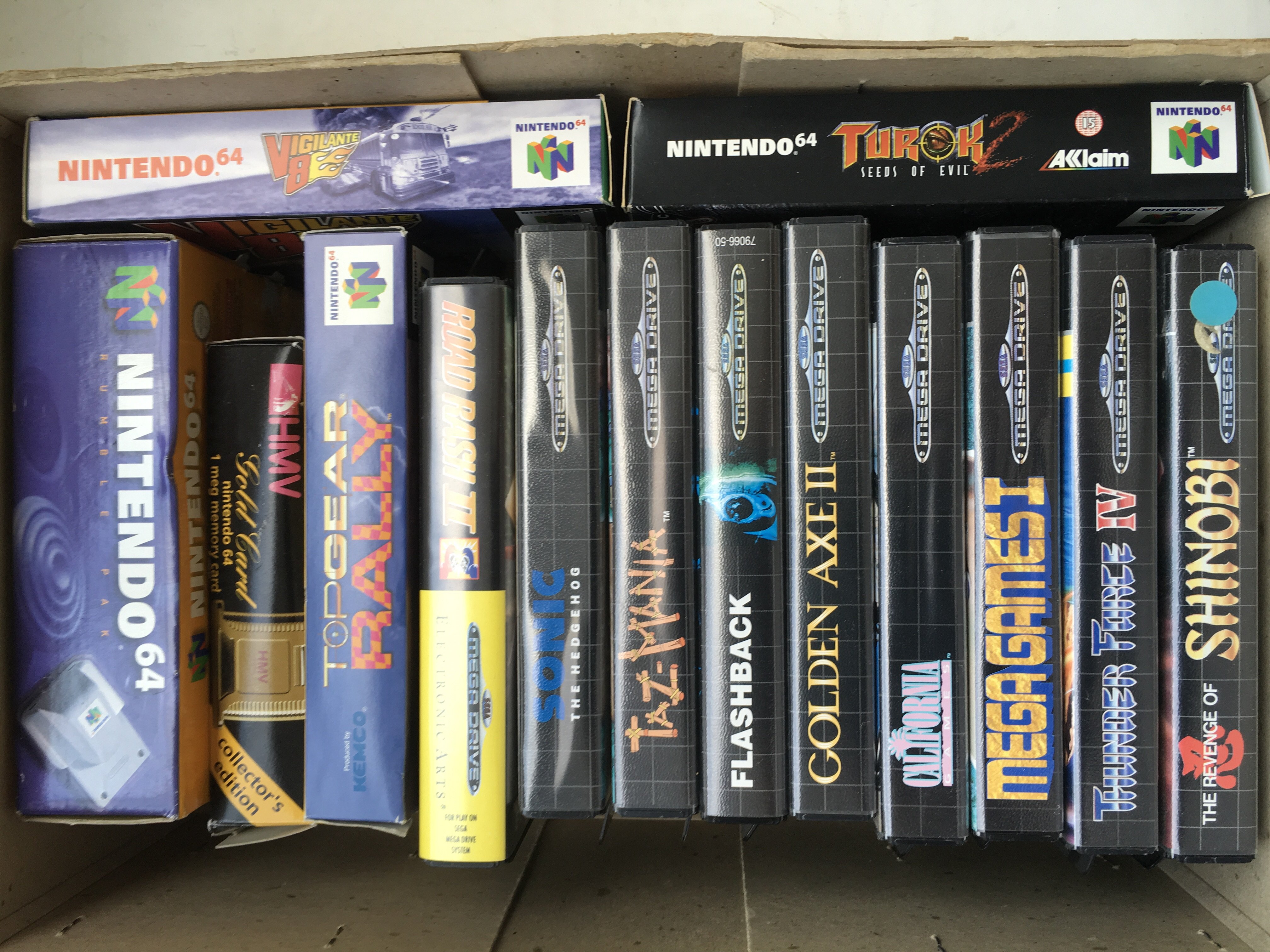 A collection of boxed games consoles including Nintendo 64 