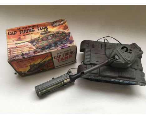 A boxed battery operated cap firing tank by Marx together with a similar US Army battery operated tank.
