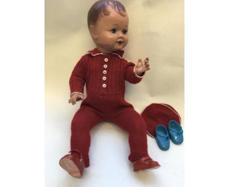 A vintage composition doll together with an Essex miniature sewing machine in a case.