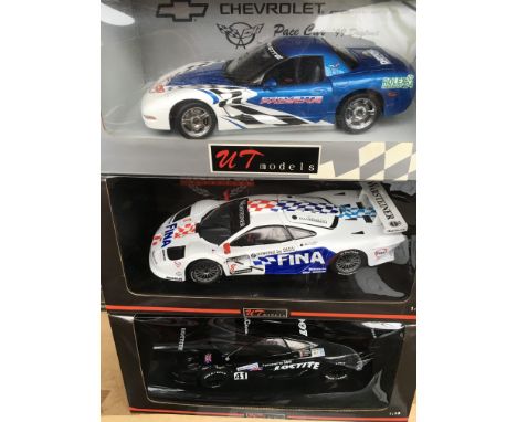 A collection of 7 mint boxed UT models 1/18 scale racing cars including the McLaren collection, a Porsche 911, and a Daytona 