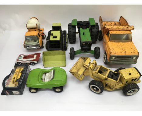 A box of Tonka toys including a flat bed Lorry, tractor, tipper truck, cement mixer, two bulldozers, a car and a buggy.