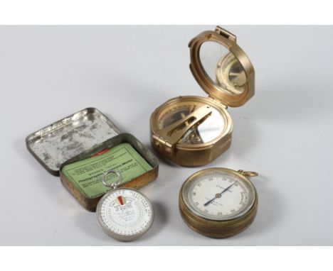 A brass cased folding compass marked Stanley, London, a military issue brass cased pocket barometer and a Wynnes photographic