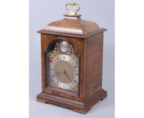 An early 20th century walnut cased bracket clock with brass carrying handle, gilt decoration, silvered dial and Roman numeral