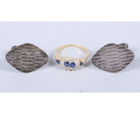 An 18ct gold, diamond and sapphire cluster ring, size P, and a pair of silver cufflinks with textured decoration