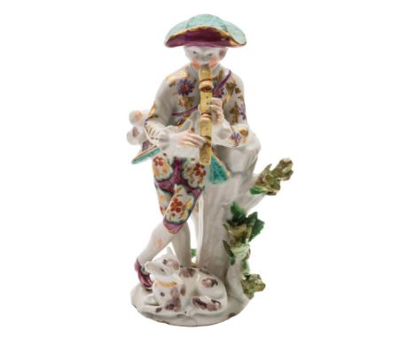 A Bow figure of a shepherd musician: standing crossed legged and playing a recorder, a bag over his shoulder and a dog at his
