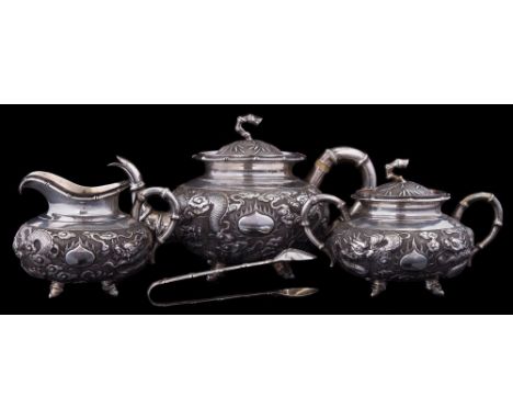 A Chinese silver three piece tea service, maker Kwan Wo, Hong Kong,: decorated overall with dragons chasing fiery pearls, wit