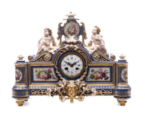 A Paris porcelain figural mantel clock: the cartouche shaped case with central mask flanked by pillars and surmounted by a pa