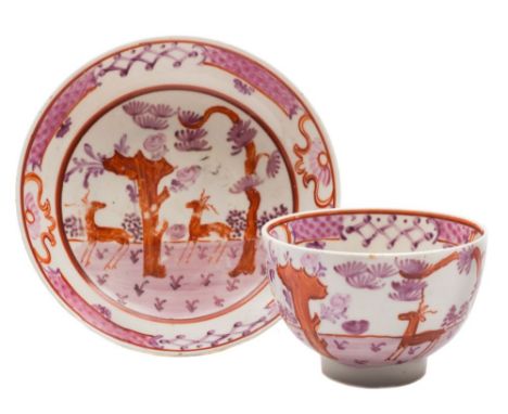 A Lowestoft tea bowl and saucer: painted in pink, purple and brick red with the 'Deer Park' pattern of two deer within a land