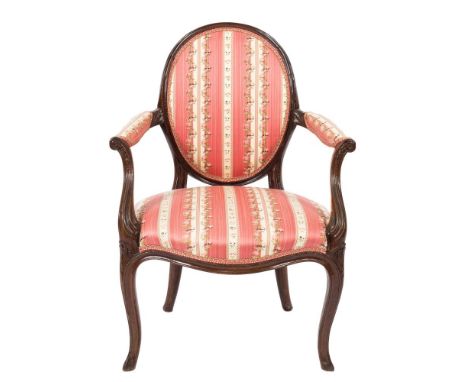 An 18th Century carved mahogany open armchair:, in the French Hepplewhite taste, the oval upholstered panel back in moulded s