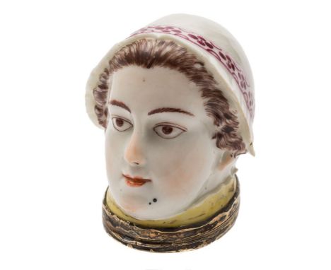A Chelsea bonbonniere: in the form of a lady's head with brown hair and four patches, wearing a pink ribbon tied bonnet, gilt
