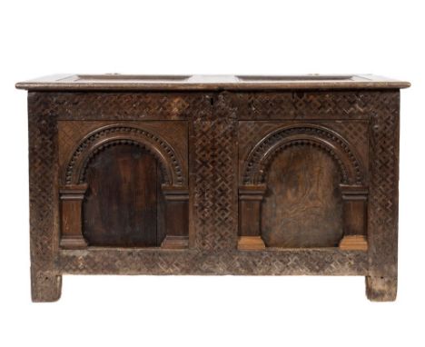 A 17th Century oak rectangular coffer:, with a plain twin moulded panel hinged top, the front with geometrically inlaid friez