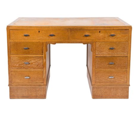 Harvey Nichols & Co, Ltd - A 1930's oak kneehole desk,: the top inset with a panel of leather, containing eight small drawers