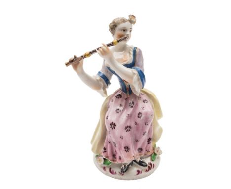 A Bow figure of a seated lady flautist: wearing a yellow cloak, blue and pale purple bodice with pink floral skirt, circa 175