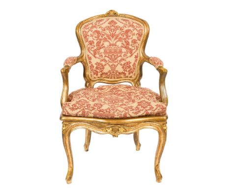 A 19th Century carved giltwood fauteuil:, in the Louis XV taste, with cane panel and upholstered cartouche-shaped back, padde